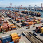 Stapel containers in een haven bij daglicht als symbool voor trage documentverwerking supply chain door bottlenecks.