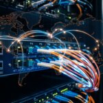 Server-Rack mit Glasfaserkabeln über einer Weltkarte; Illustration der Risiken für die Datensouveränität bei der Datenerfassung