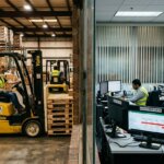 Logistics workers and accountants dealing with delayed invoicing in holding structures due to master data errors.