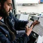 Logistics worker scanning a crumpled CMR consignment note to resolve OCR failures during freight document processing.