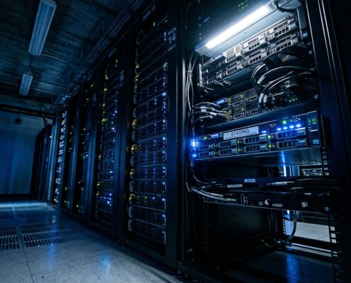 Blauw verlichte serverruimte met focus op een staging blade; toont beveiligingsrisico staging omgeving logistiek.